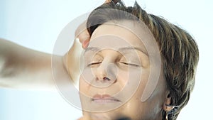 Close-up of professional make-up artist doing everyday makeup, puts powder on womans cheeks with brush