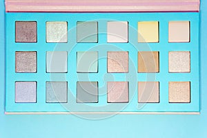 Close-up of professional makeup eye shadows on a blue background. Fashion and beauty concept.