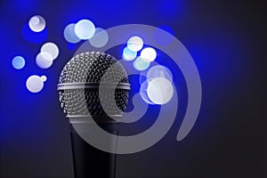 Close up of a professional microphone with blue blurred lights i