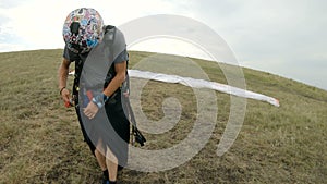 Close-up professional paraglider pilot prepares for takeoff, buttoning equipment and straightening slings