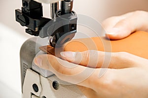Close up of professional sewing machine for leather work, woman`s hands
