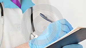 Close-up of professional therapist hands signing medical document on clipboard.