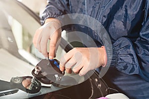 Close-up of a professional windshield repairman working with hydraulic polymer crack filler. Elimination of cracks and