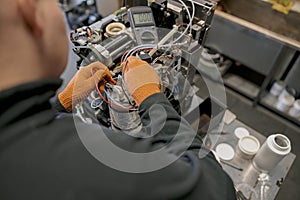 Professional worker fixing coffee machine in workshop