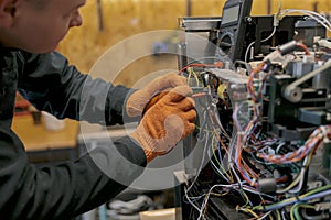 Professional worker fixing coffee machine in workshop