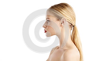 Close-up profile face of beautiful young woman posing at isolated white background