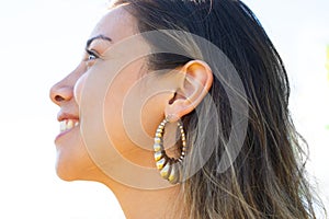 Close up profile portrait of an attractive, woman with long hair and earrings