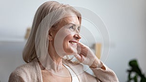 Close up profile smiling mature woman dreaming about good future