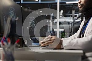 Close up of programmer in data center using AI powered tech to run simulations