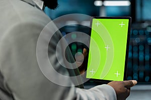 Close up of programmer in data center using isolated screen tablet