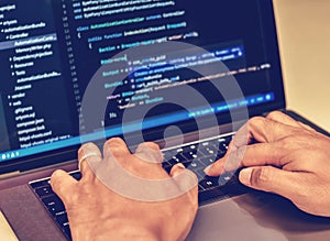 Close-up of a programmer`s hands writing source codes.