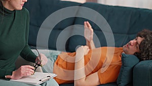 Close up of psychologist writing and male patient answering questions in office passing psychological test for diagnosis