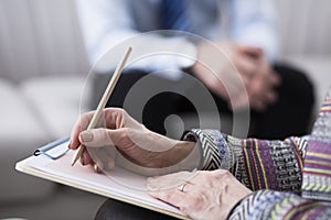 Close-up of psychotherapist writing notes