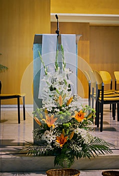 close-up of the pulpit & x28;ambon& x29; in a modern Catholic church with flower decoration in the foreground