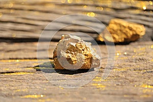 Close up pure gold minerals with golden light on old wooder background, investment and business concept