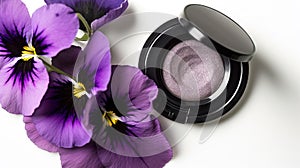 a close up of a purple flower and a black and white eye shadow on a white surface with purple flowers on the side of the