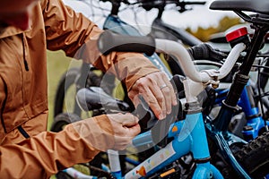 Close-up of putting bicycles on car rack.