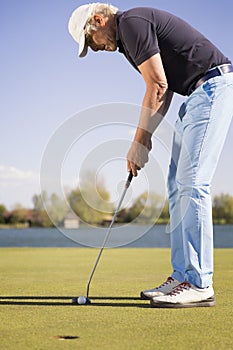 Close up of a putting golf player.