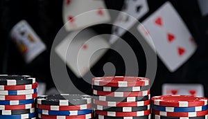 Close-up, pyramid of multi-colored chips, for playing poker, on a black background and flying cards