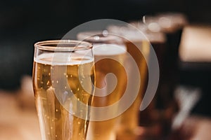 Close up of a rack of different kinds of beers, dark to light, on a table.