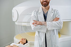 Close up of radiologist controls MRI or CT or PET Scan with female patient undergoing procedure