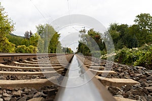 Close-up of railroad tracks leading straight foreward to infinity