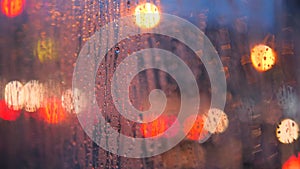 Close Up Rain Drops on Car Window Glass with Blurred Night City Car Lights Bokeh as Background. 4K.