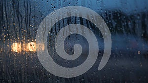 Close Up Rain Drops on Misted Car Window Glass with Blurred Night City Car Lights Bokeh as Background. 4K.