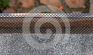 Close up of rain gutter on home covered in mesh to keep leaves out