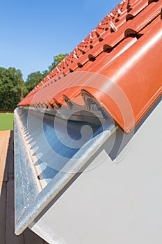 Close up rain gutter with new roof tiles