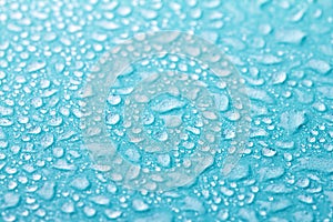 Close up rain water drops on blue sponge surface as abstract background