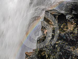 Close up of a rainbow on the edge of ferguson falls on tasmania`s popular overland track photo