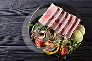 Close up of rare seared Ahi tuna slices with fresh vegetable sal