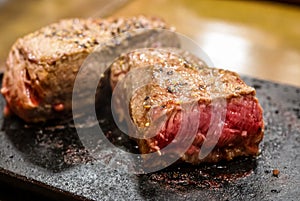 Close up of a rare steak on a black stone plate