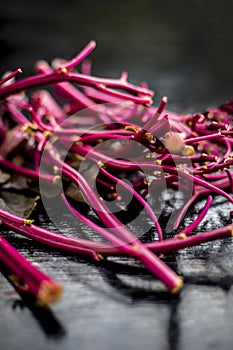 Close up of raw amaranth leaves`s branches on wooden surface without its leaves.