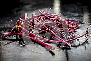 Close up of raw amaranth leaves`s branches on wooden surface without its leaves.