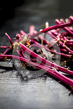 Close up of raw amaranth leaves`s branches on wooden surface without its leaves.