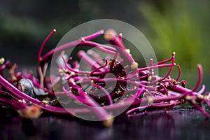 Close up of raw amaranth leaves`s branches on wooden surface without its leaves.