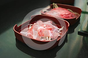 Raw fillet pork and beef sliced on red dish photo