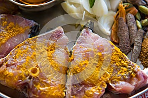 Close up of raw fish in turmeric powder with use of selective focus on a particular tip of fish meat