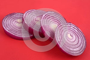 Red onion rings cut in close-up on red  background
