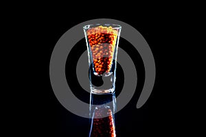 Close up of Raw Masur dal or masoor lentils or pink lentils in a black colored clay bowl on black in wineglass glass jar bucket