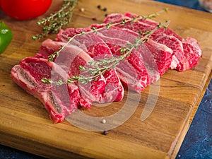 Close-up. Raw meat steaks with rosemary on a wooden cutting board. Ready for grilling. Picnic, barbecue. Family traditions.