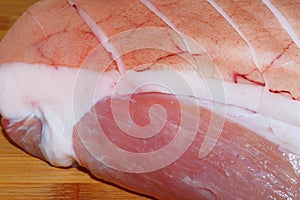 Close-up of raw roast pork with a crust on wooden background