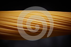 Close-up of raw spaghetti on a black background