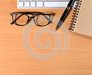 Close up Reading Eye Glasses on Businessman Wooden Table with Ot