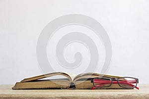 Close-up of a reading glasses on an open book on a white background