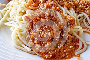 Close up spaghetti with sauce on white plate