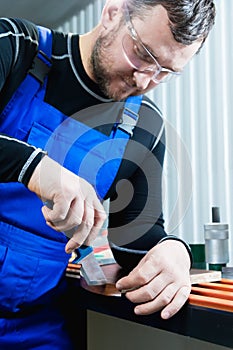 A close-up of the real male carpenter`s not well-groomed completes the finish of the chipboard details of the furniture