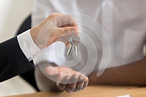 Close up of realtor give keys to property buyer